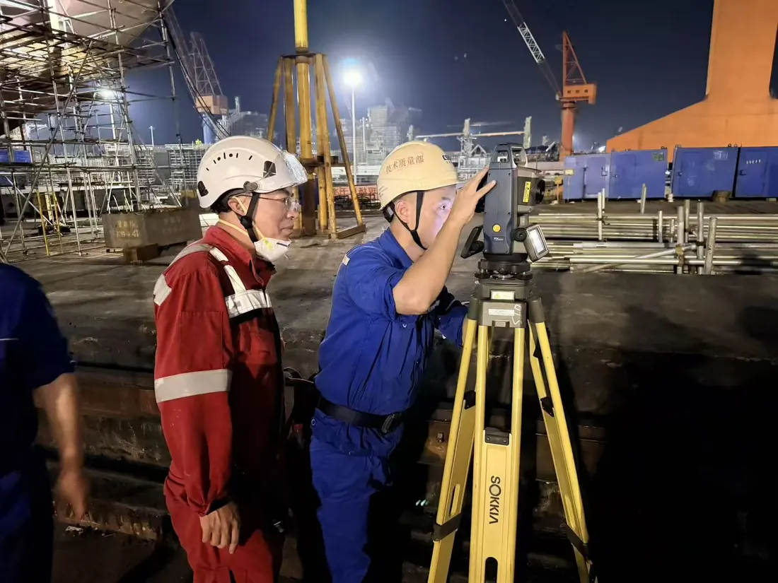 Marine professionals carrying out precision survey work in a shipyard