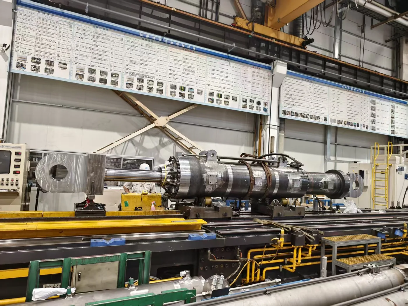 Large hydraulic cylinder undergoing inspection in a manufacturing workshop